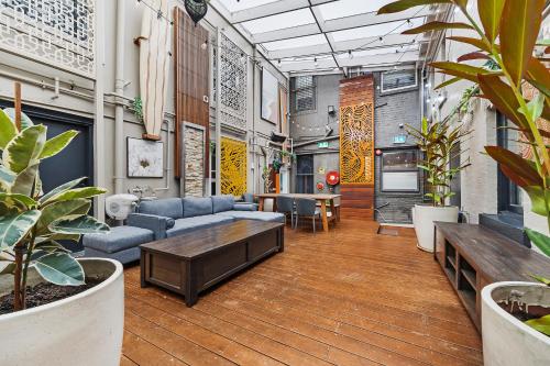 悉尼London Plane Backpackers的客厅里摆放着家具和植物