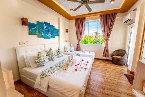MahibadhooVilu Thari Inn Maldives的卧室设有一张白色大床和一扇窗户。