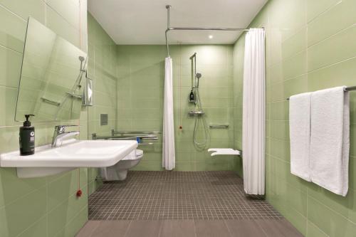 科布伦茨Super 8 by Wyndham Koblenz的绿色浴室设有水槽和淋浴