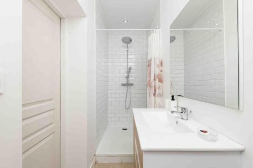 梅里尼亚克La Contemporaine的白色的浴室设有水槽和淋浴。