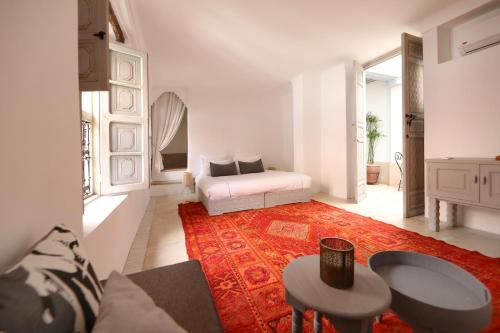 马拉喀什Riad Les Hirondelles Boutique Hotel的白色的客厅,配有床和红色地毯