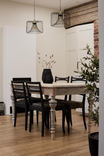 维尔扬迪Vaksali Apartment!的一张餐桌,配有黑色椅子和花瓶