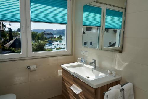 玛丽亚韦尔特Appartements am See的一间带水槽的浴室和两个窗户