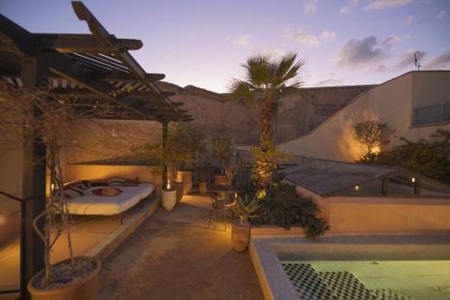 马拉喀什Riad Les Hirondelles Boutique Hotel的一个带床和游泳池的庭院