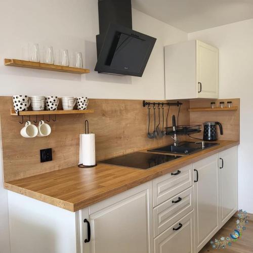 GowidlinoStudio 4-osobowe的厨房配有白色橱柜和木制台面
