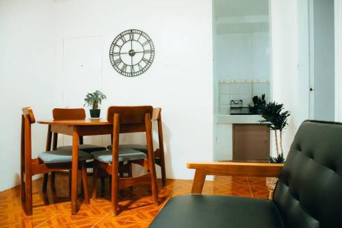 MatinkananaRelaxing & Accessible Apartment的一间带桌椅和时钟的用餐室