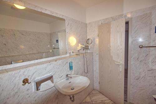 ScheibenbergHotel Sächsischer Hof的白色的浴室设有水槽和镜子