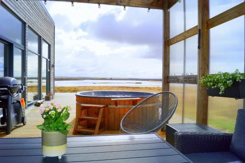 劳加尔瓦特恩Austurey - Lakefront Villa的一个带桌椅的海景门廊