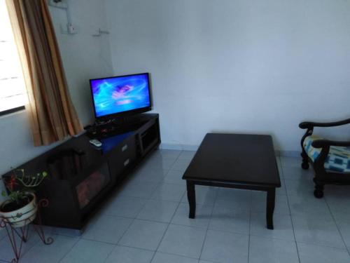 马六甲365 by D'Laksamana的客厅配有电视和桌子