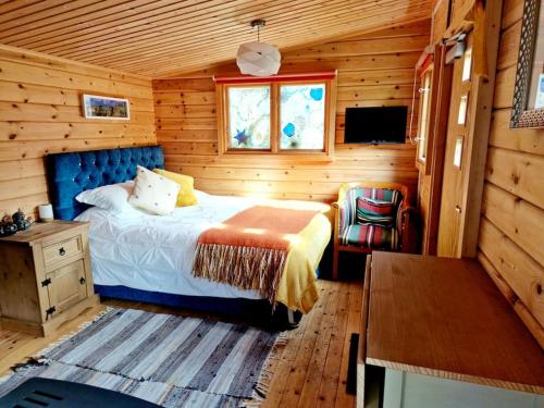 多切斯特Piddle Puddle Cabin的小木屋内一间卧室,配有一张床