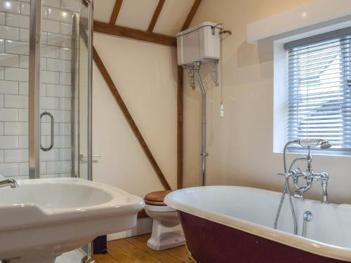 AdstockWayside Cottage的带浴缸、盥洗盆和卫生间的浴室