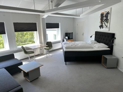 Løgstør勒格斯特公园酒店的一间卧室配有一张床、一张沙发和一张桌子