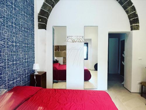 马尔萨拉Controvento B&B的一间卧室配有红色的床和镜子