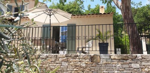 PierrevertUne maison en Provence的一个带伞和石墙的围栏