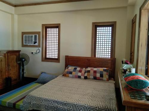 Ohana Resort的一间卧室设有一张床和两个窗户。