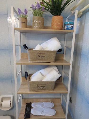 卡利斯托斯Eva's apartment的浴室里装有三篮毛巾的架子