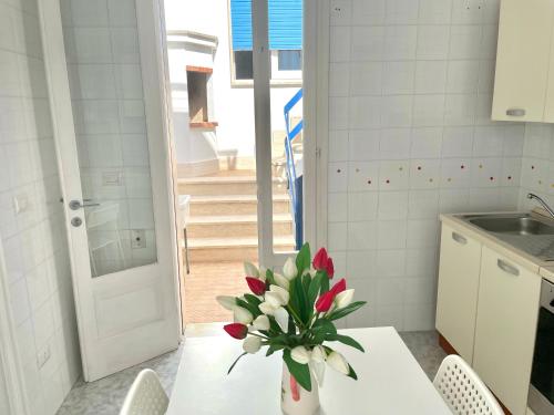 玛丽娜迪曼卡维萨Villa Azzurra的厨房配有一张桌子,上面放着花瓶