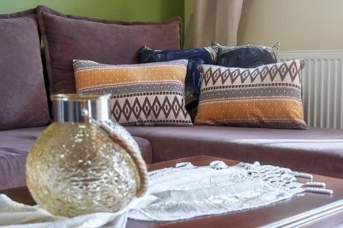 拉里萨Το πιο ευχάριστο διαμέρισμα της πόλης的沙发上带花瓶的茶几