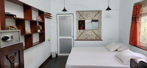 加姆珀哈CHARAKAMA Guest Bungalow - GAMPAHA的小房间设有床和镜子