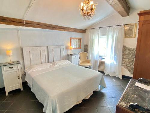 东塞斯特里AGRITURISMO CASA OLIVIERI的卧室配有一张白色大床和吊灯。