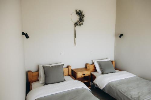 DurbeDurbes Atvari - brīvdienu mājas ar saunu的一间设有两张床的客房和墙上的时钟