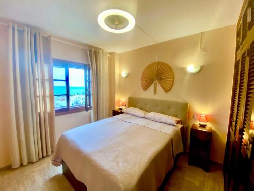 托雷维耶哈Beautiful apartment near LaMata Beach with PANORAMA SEA view!!!的一间卧室设有一张大床和一个窗户。