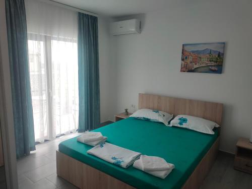 图兹拉Vila La Fernando的一间卧室配有一张带毛巾的大型绿床