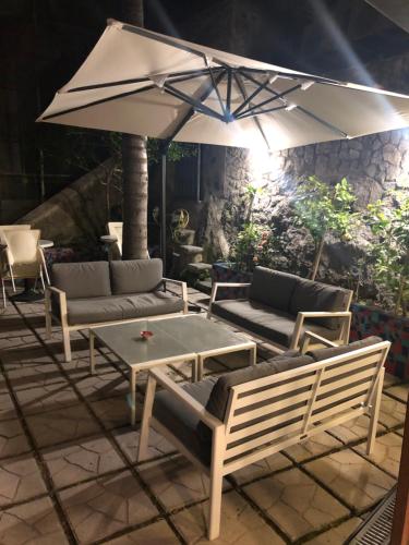 米诺利帕拉佐维吉优斯酒店的庭院配有桌椅和遮阳伞。