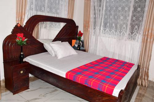 蒙巴萨Donita's Seaview Apartments的一间卧室配有一张带红色和蓝色毯子的木床
