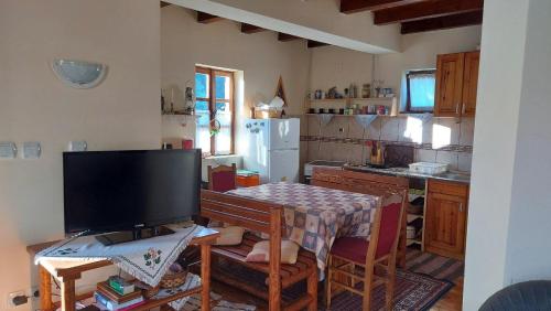 ZaovineApartment ''Planinsko selo''的厨房配有电视和带桌子的桌子。