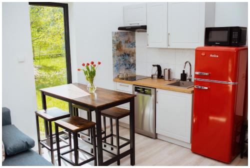 SzramowoEnklava的厨房配有红色冰箱、桌子和椅子