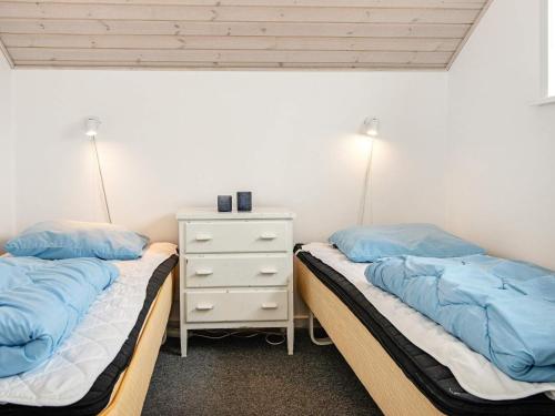 森讷比Holiday Home As Hedegård II的一间卧室设有两张床和床头柜