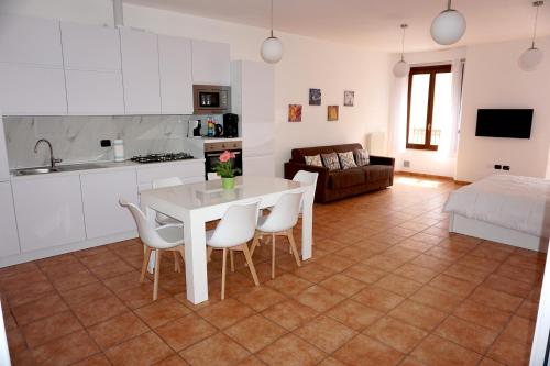 里米尼Appartamento in piazza CAVOUR centro storico Rimini的厨房以及带白色桌椅的起居室。
