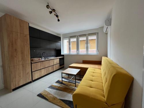 皮罗特Apartment Monaliza的一间带黄色沙发的客厅和一间厨房