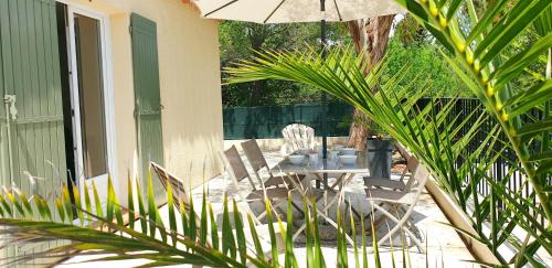 PierrevertUne maison en Provence的庭院配有桌椅和遮阳伞。