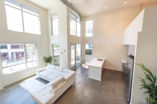 洛杉矶1500 Sq foot, 3 bed room loft in DTLA (Pool & Hot tub!)的客厅配有白色的沙发和桌子