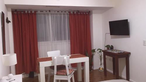 布宜诺斯艾利斯Palermo Botánico的客厅配有桌子和红色窗帘