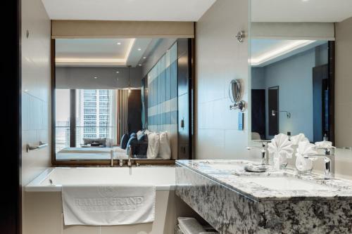 迪拜Ramee Dream Hotel Downtown的一间带两个盥洗盆和大镜子的浴室