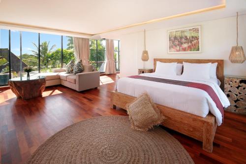 乌鲁瓦图巴里坎达西尔酒店的一间卧室设有一张大床和一个大窗户
