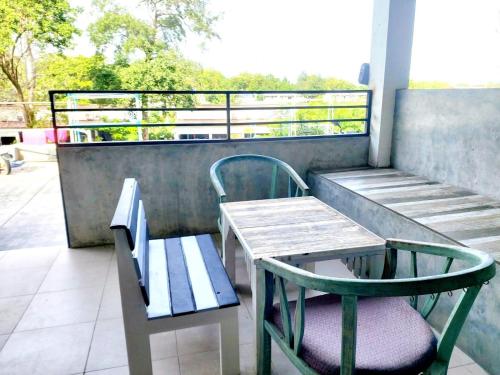 沙美岛Baan Minnie 2 bedroom home 400m from Saikaew beach的阳台的长椅、桌子和椅子