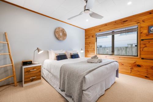 芒格努伊山The Iconic Kiwi Bach, Full Site Downtown Mount的一间卧室设有一张床和一个窗口