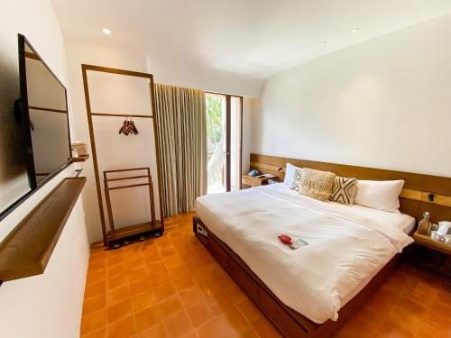吉利特拉旺安Hotel Lumi Gili Trawangan的一间卧室设有一张床和一个大窗户