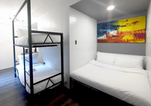 马尼拉mySTAY Hotel BGC South的一间卧室配有两张双层床和一幅画