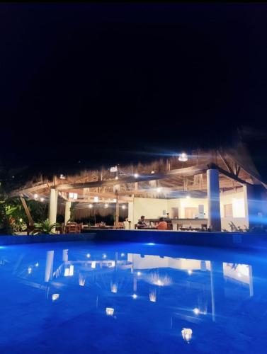 卢纳将军城Tropical Bungalows-Siargao的享有游泳池的夜间景致