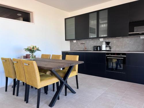 卡拉约基Villa Resort Apartments by Hiekka Booking的厨房配有木桌和黄色椅子