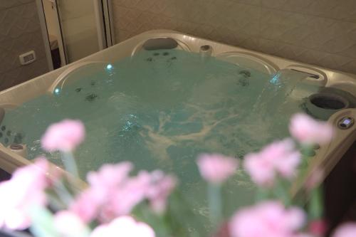 Kefar Weradimצימר ספא的浴缸里装满了绿水和粉红色的花卉