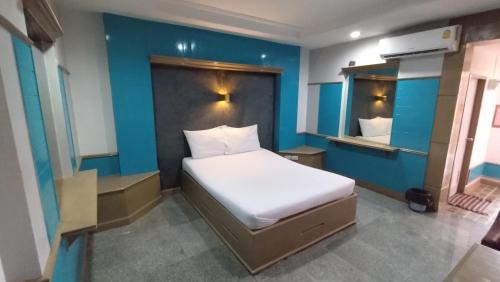 北标府MP Inn的一间卧室设有一张床和蓝色的墙壁