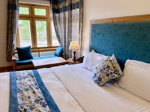 列城hotel palam hills的一间卧室配有一张大床和蓝色床头板
