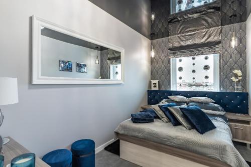 吉日茨科#MazuryGlamour的一间卧室配有一张带蓝色床头板和镜子的床