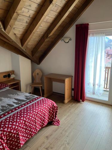 拉瓦罗内Giongo Residence - Appartamenti的一间卧室设有一张床和一个大窗户